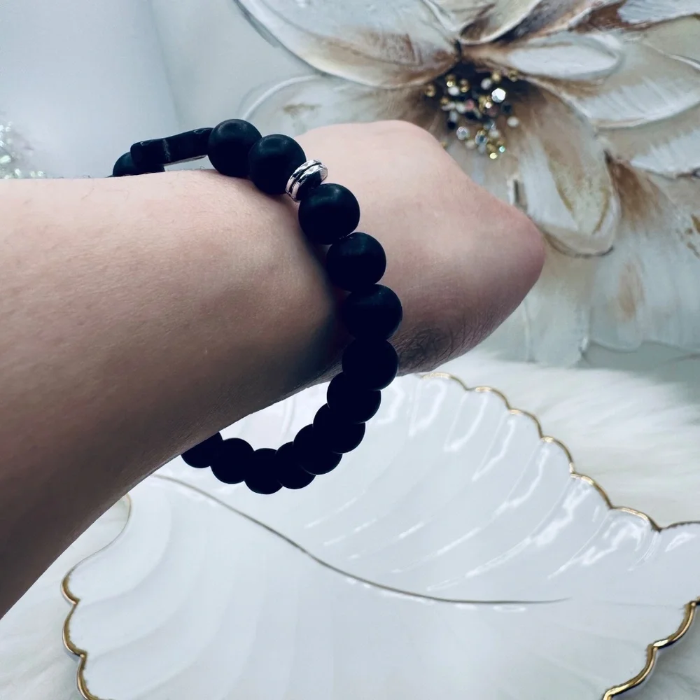 This elegant bracelet features smooth matte black beads paired with a bold black